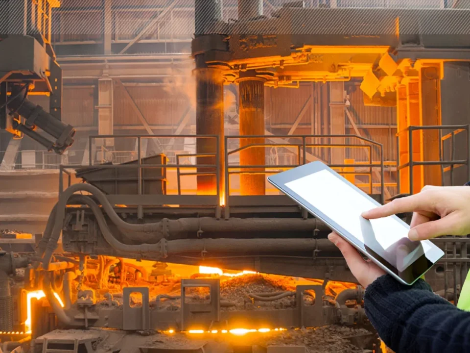 engineer holding tablet in front of metallurgy plant